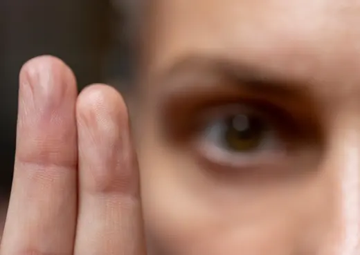 Nahaufnahme eines Auges, davor bewegt sich ein Finger